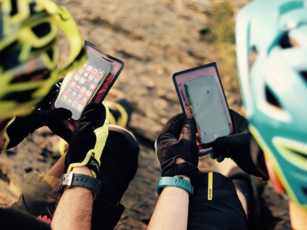 Over Shoulder View of Mountain Bikers Using Phone Wallet